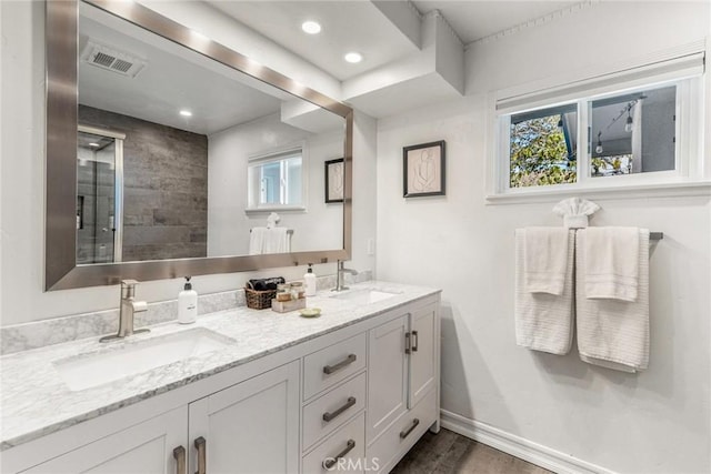 full bath featuring double vanity, visible vents, a sink, and wood finished floors