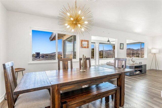 dining room featuring wood finished floors, baseboards, and a notable chandelier