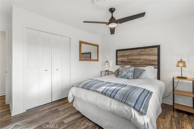 bedroom with a closet, a ceiling fan, wood finished floors, and baseboards