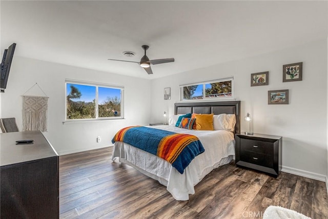 bedroom featuring multiple windows, baseboards, and dark wood-style floors