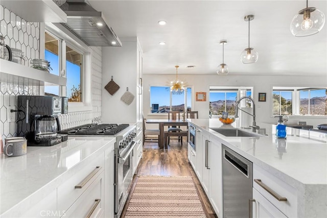 kitchen with appliances with stainless steel finishes, recessed lighting, a sink, white cabinets, and light wood-type flooring