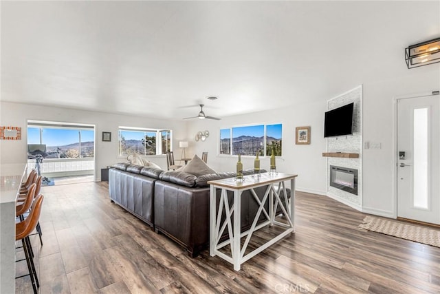 54660 Benecia Trl, Yucca Valley, CA 92284 - living area with a stone fireplace, wood finished floors, ceiling fan, and baseboards