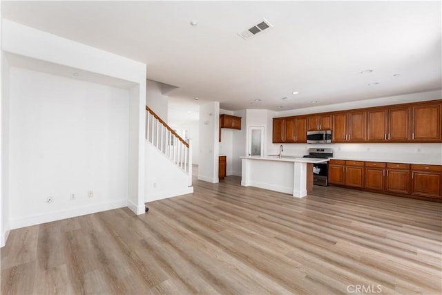 1677 Catania Dr, Riverside, CA 92507 - kitchen with light wood-type flooring, light countertops, stainless steel appliances, and brown cabinets
