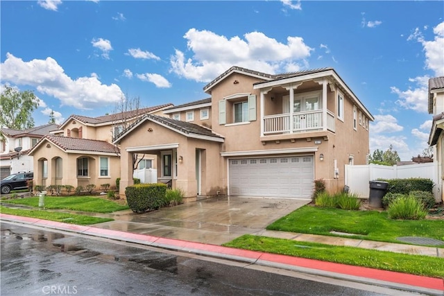 1677 Catania Dr, Riverside, CA 92507 - mediterranean / spanish house featuring a balcony, driveway, fence, an attached garage, and stucco siding