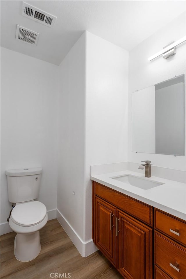 1677 Catania Dr, Riverside, CA 92507 - bathroom featuring visible vents, baseboards, toilet, wood finished floors, and vanity