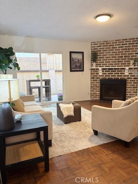 living room featuring a textured ceiling and a brick fireplace