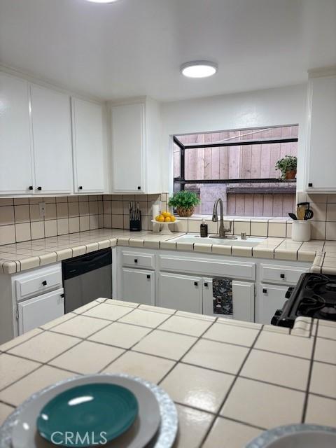 kitchen with a sink, white cabinets, and decorative backsplash