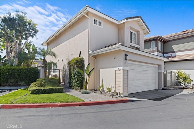 view of property exterior featuring stucco siding, an attached garage, driveway, and fence