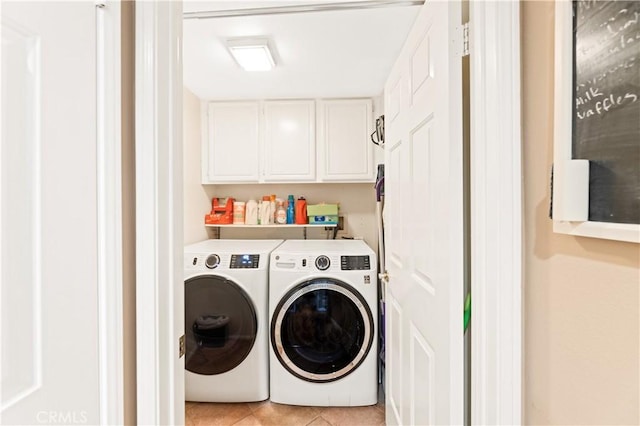 laundry room featuring washer and dryer, cabinet space, and light tile patterned floors
