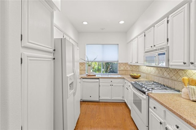 kitchen featuring decorative backsplash, white appliances, light wood finished floors, white cabinetry, and recessed lighting