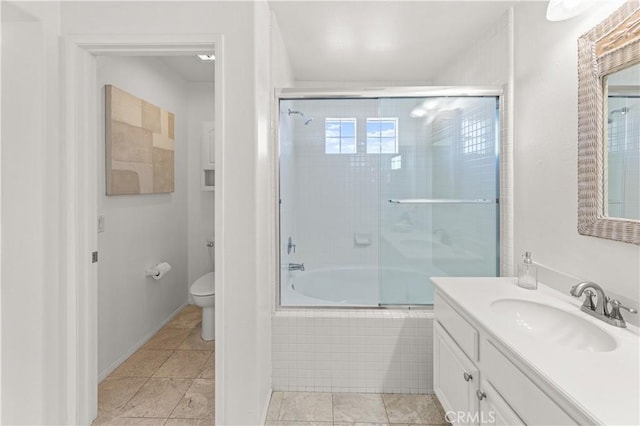 bathroom featuring tile patterned flooring, toilet, vanity, and tiled shower / bath combo