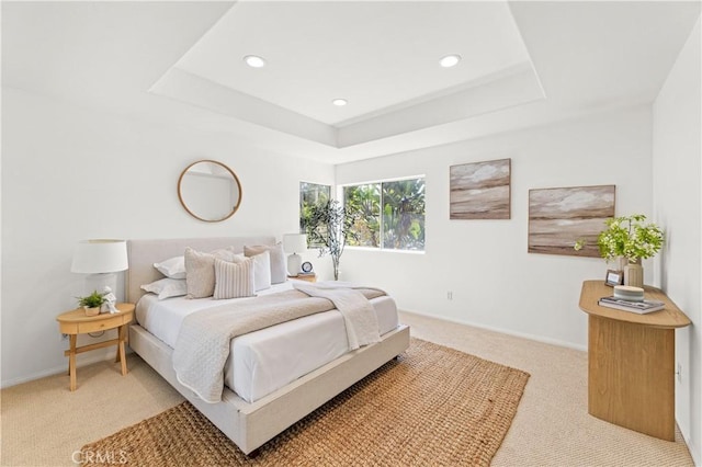bedroom with light carpet, baseboards, a tray ceiling, and recessed lighting