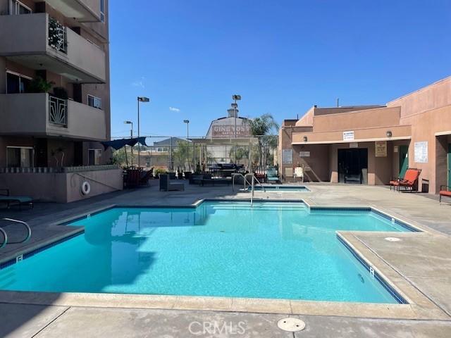 community pool featuring a community hot tub and a patio area
