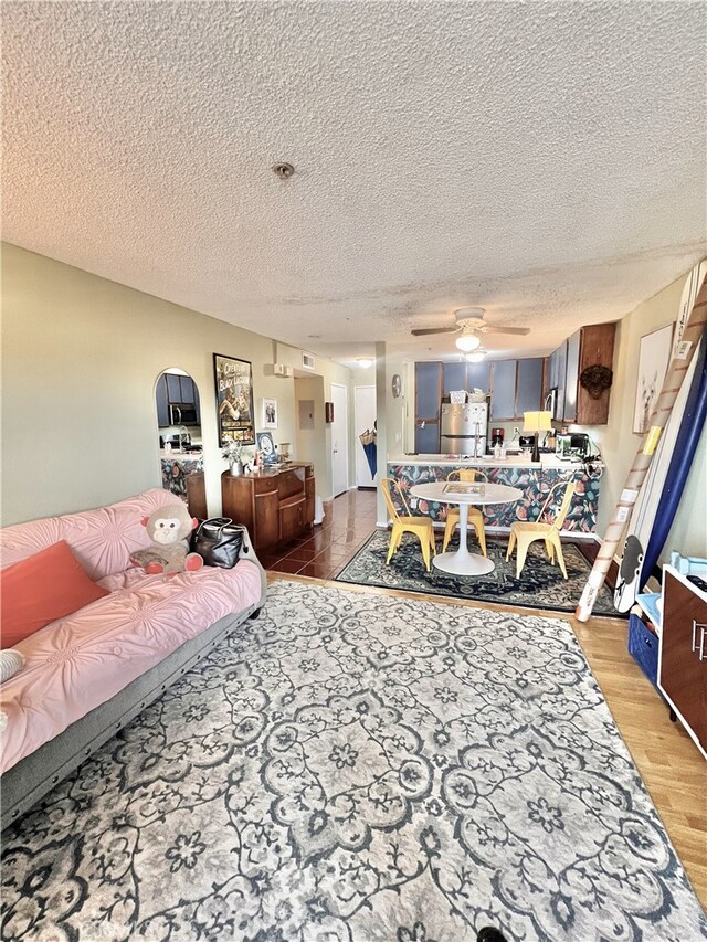 450 E 4th St Unit 304, Santa Ana, CA 92701 - living room featuring a textured ceiling, ceiling fan, and light wood-style floors