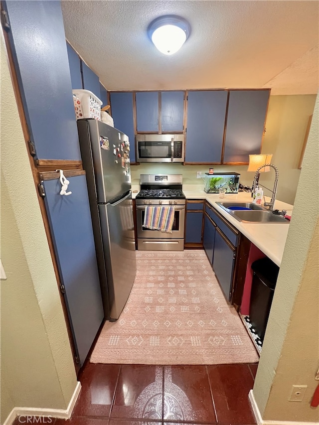 450 E 4th St Unit 304, Santa Ana, CA 92701 - kitchen with appliances with stainless steel finishes, a sink, blue cabinets, light countertops, and a textured ceiling