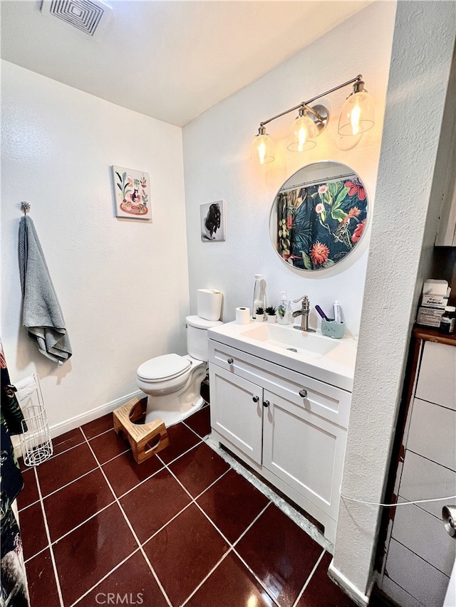 bathroom with tile patterned floors, vanity, baseboards, toilet, and visible vents
