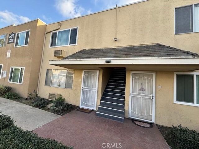 505 E Madison Ave Unit 84, El Cajon, CA 92020 - property entrance with central AC unit, a wall mounted air conditioner, and stucco siding