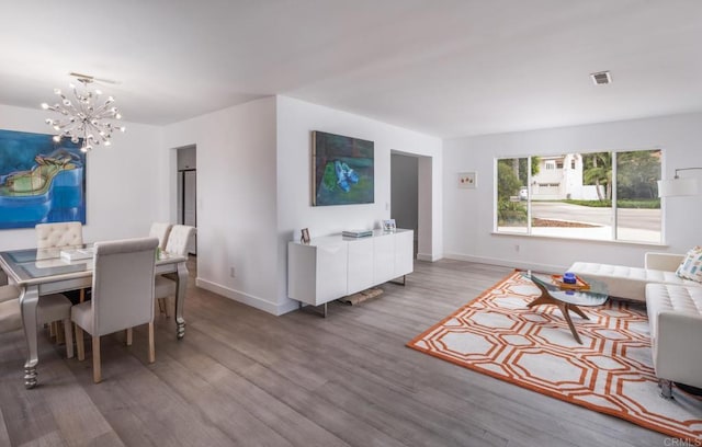 living room with a chandelier, wood finished floors, and baseboards