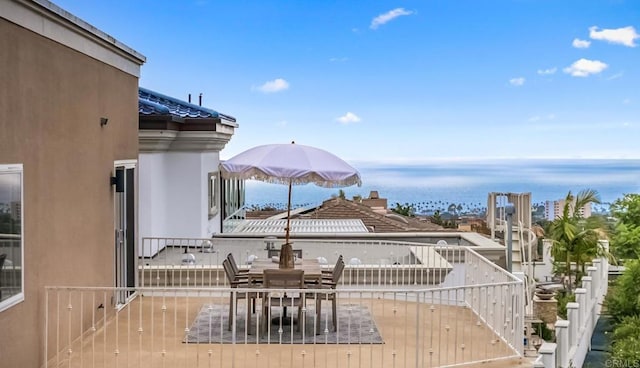 wooden deck featuring outdoor dining area and a water view