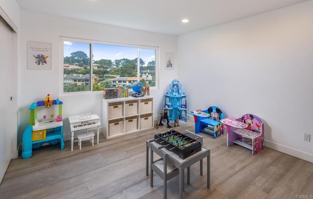 recreation room featuring wood finished floors, recessed lighting, and baseboards