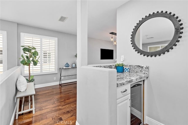 515 N Gertruda Ave Unit 9, Redondo Beach, CA 90277 - kitchen with beverage cooler, dark wood finished floors, baseboards, white cabinetry, and light stone counters