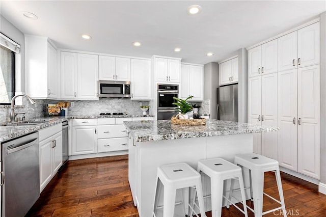 515 N Gertruda Ave Unit 9, Redondo Beach, CA 90277 - kitchen featuring appliances with stainless steel finishes, a sink, a breakfast bar, dark wood-style floors, and recessed lighting
