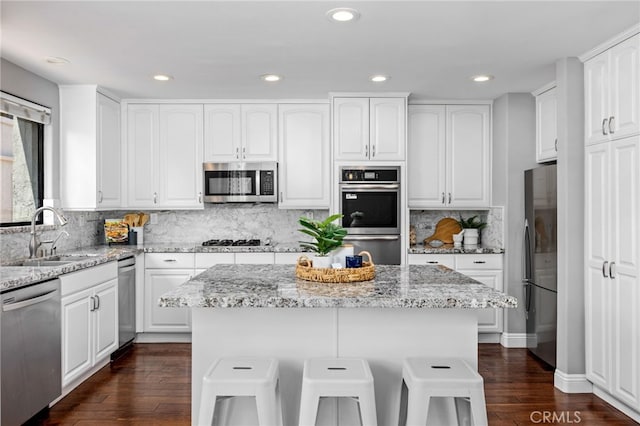 515 N Gertruda Ave Unit 9, Redondo Beach, CA 90277 - kitchen featuring a sink, stainless steel appliances, dark wood finished floors, white cabinetry, and light stone counters
