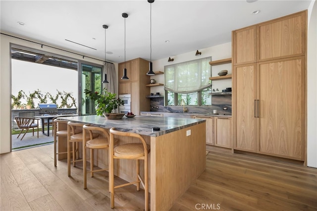 4209 Vantage Ave, Studio City, CA 91604 - kitchen featuring open shelves, light wood-style flooring, a kitchen island, a kitchen breakfast bar, and light brown cabinets