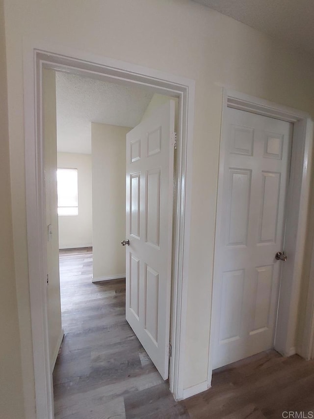 hall featuring baseboards and wood finished floors