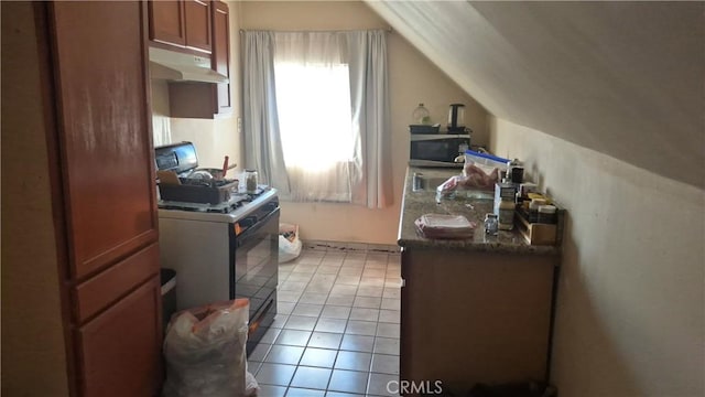 kitchen featuring dark countertops, stainless steel microwave, vaulted ceiling, under cabinet range hood, and gas range oven