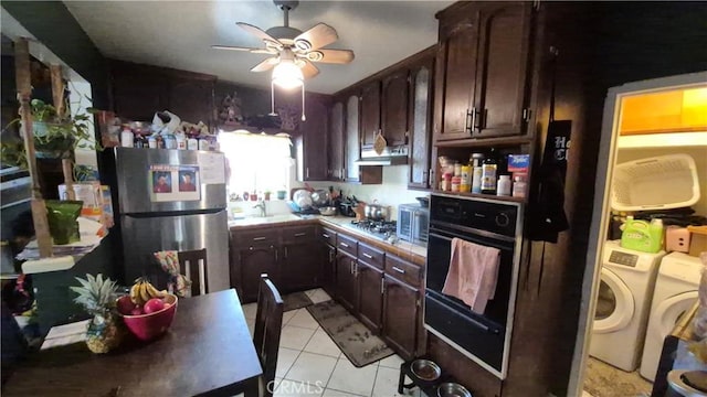 kitchen with independent washer and dryer, dark brown cabinets, ceiling fan, appliances with stainless steel finishes, and light tile patterned floors