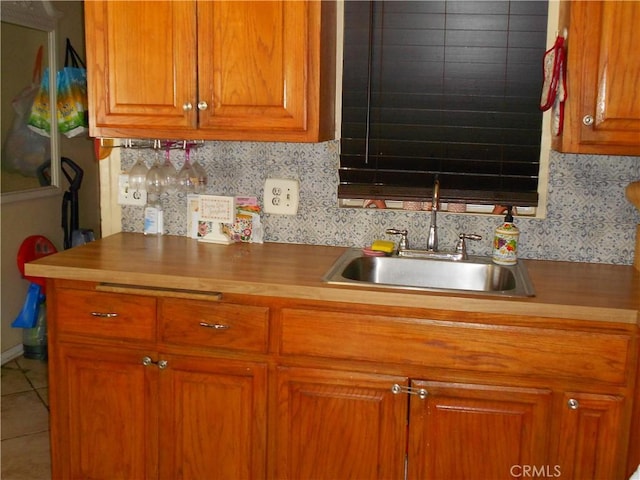 1312 Pleasant Vw, Corona, CA 92882 - kitchen with brown cabinetry, a sink, wood counters, tile patterned floors, and tasteful backsplash