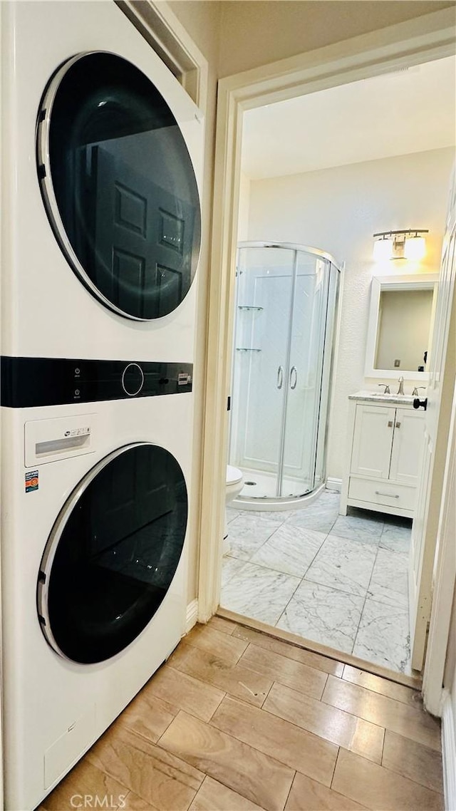 120 Timberwood, Irvine, CA 92620 - clothes washing area featuring stacked washing machine and dryer and baseboards