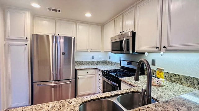 120 Timberwood, Irvine, CA 92620 - kitchen featuring stainless steel appliances, a sink, white cabinetry, light stone countertops, and recessed lighting