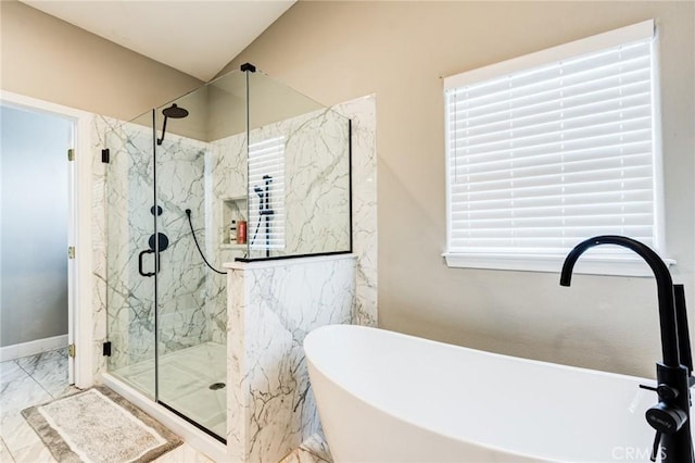 full bath featuring a freestanding tub, marble finish floor, a sink, a marble finish shower, and baseboards