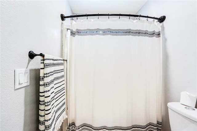 bathroom with a shower with curtain and toilet