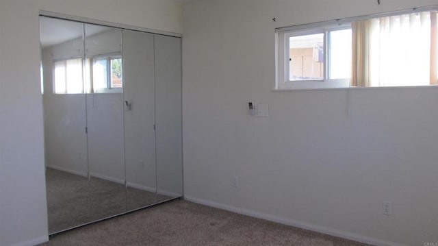 unfurnished bedroom with carpet floors, baseboards, and a closet