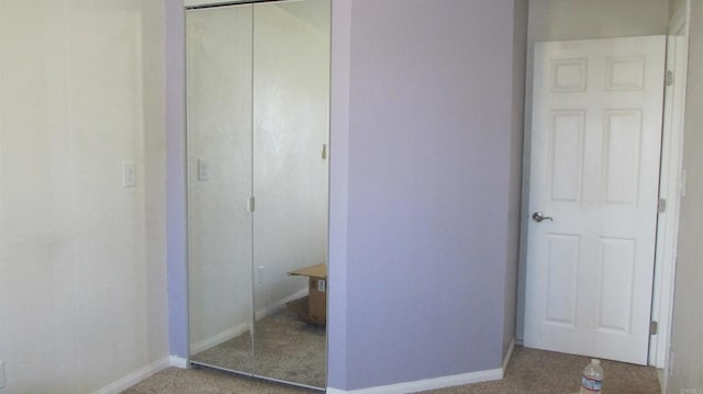 interior space featuring carpet flooring, baseboards, and a closet