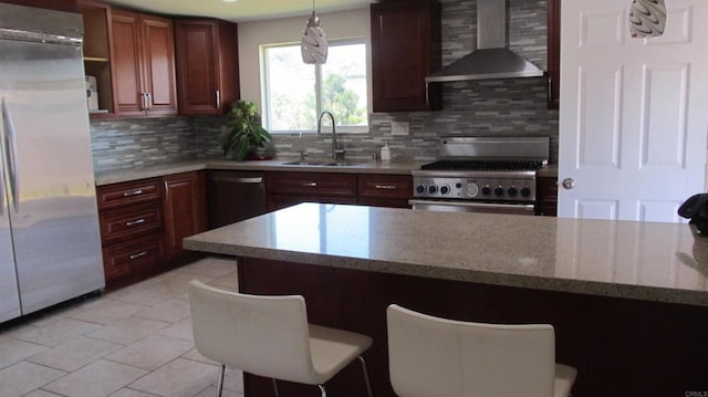 kitchen featuring tasteful backsplash, a sink, light tile patterned floors, stainless steel appliances, and wall chimney exhaust hood