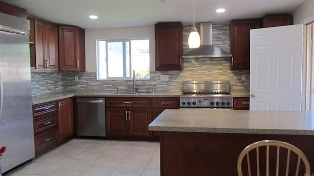kitchen featuring appliances with stainless steel finishes, a sink, light countertops, wall chimney exhaust hood, and light tile patterned floors