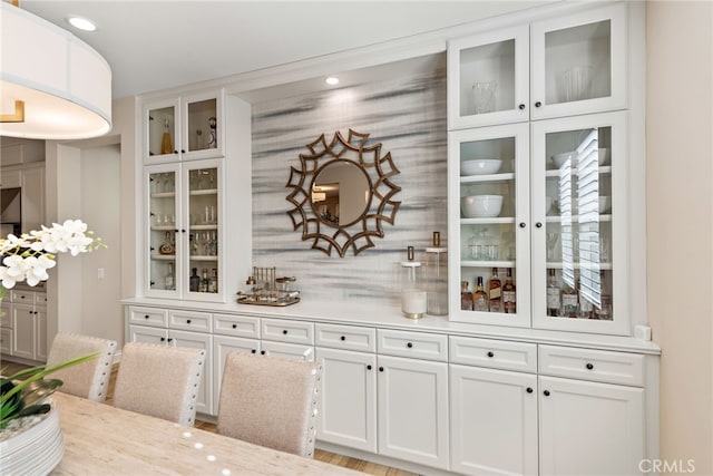 kitchen with white cabinetry, light countertops, and glass insert cabinets