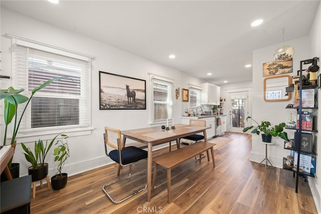dining space with baseboards, wood finished floors, and recessed lighting