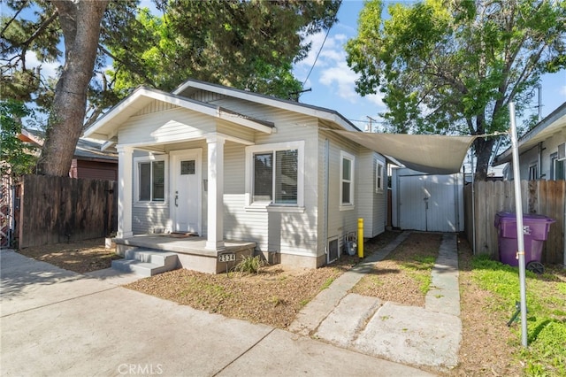 view of front of home featuring a storage shed, concrete driveway, a carport, an outdoor structure, and fence