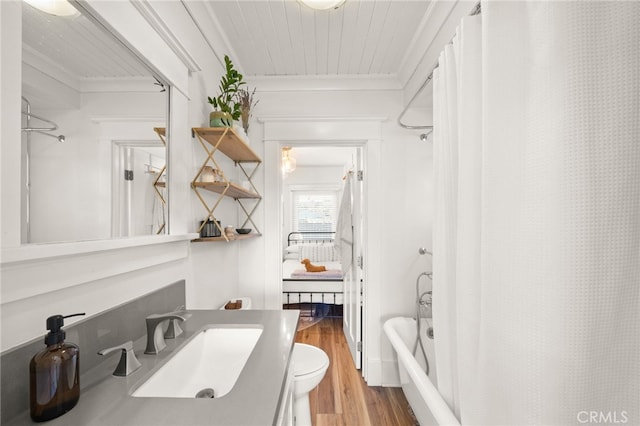 full bathroom with wood finished floors, toilet, vanity, ornamental molding, and shower / tub combo