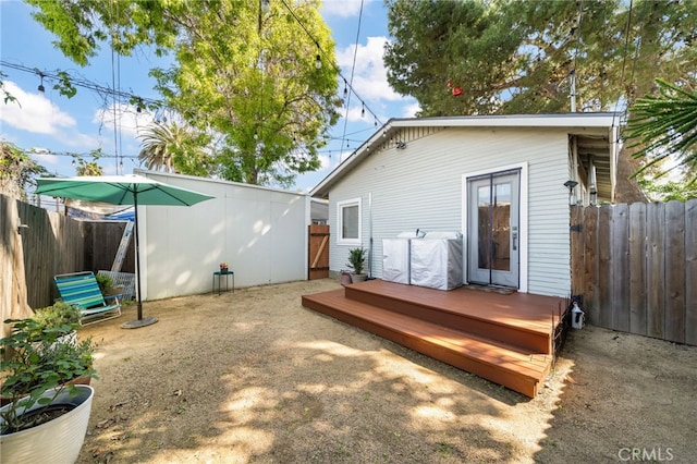 rear view of house with a fenced backyard and a deck
