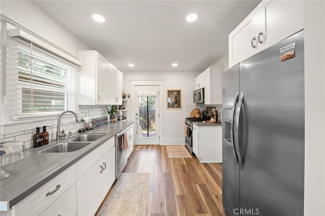 kitchen featuring a sink, tasteful backsplash, recessed lighting, white cabinetry, and appliances with stainless steel finishes