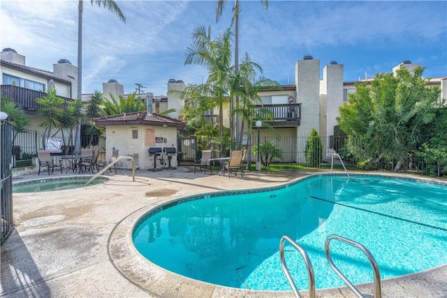 pool with a patio area and fence