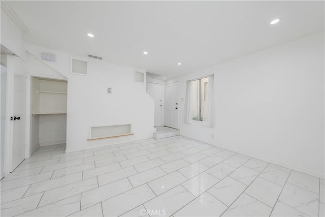 spare room with recessed lighting, visible vents, and marble finish floor