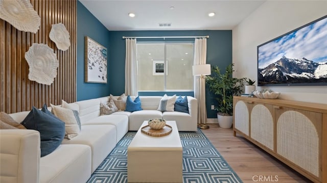 living room with recessed lighting, visible vents, and wood finished floors