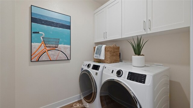 laundry area with washer and dryer, baseboards, and cabinet space